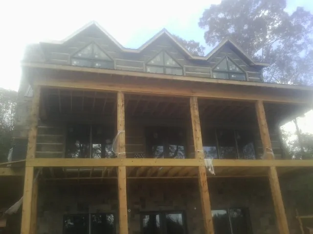 Dormers and porch framing on a large log home under construction — Roof Coating work by our crew in Cochecton
