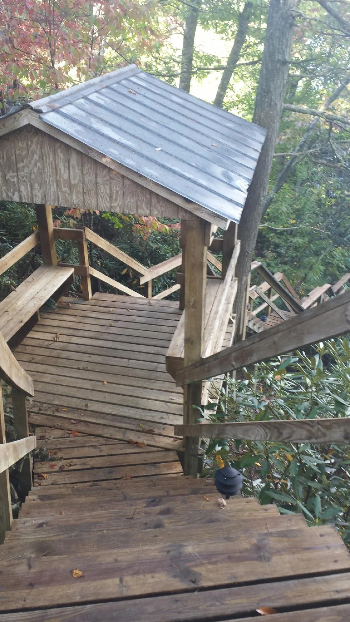 Metal roofed shelter over wooden steps on a wooded walkway — Skylight Repair & Installation work by our crew in Cochecton